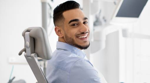 Dental Clinic Patient. Portrait of Smiling Male Posing in Dentist Chair
