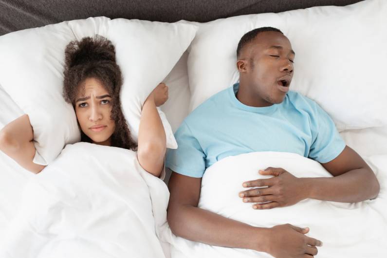 Snoring man sleeping with apnea and sleepless woman, angry wife unable to get to sleep